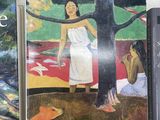 several books on a table with a painting of a woman in a white dress
