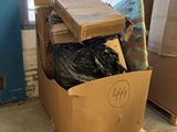 a cardboard box full of clothes sitting on a pallet in front of a window