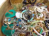 a wooden bowl filled with lots of assorted jewelry