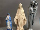 Plusieurs figurines représentant Jésus et Marie sont exposées sur une table