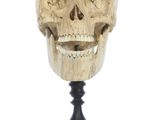 an image of a wooden skull head on a stand on a white background