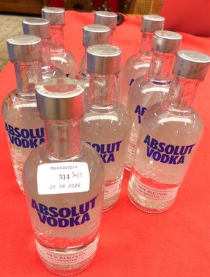 six bouteilles de vodka Absolut posées sur une table rouge