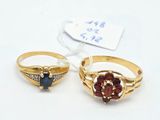two gold rings with garnets and diamonds on them