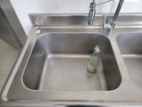 a bottle of water in a sink with a faucet in it