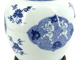 a blue and white vase on a wooden stand