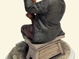 a figurine of a man sitting on a bench with a dog