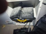 a black suitcase with a yellow handle sitting on a cart
