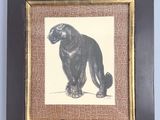 painting of a black bear in a brown frame on a blue wall