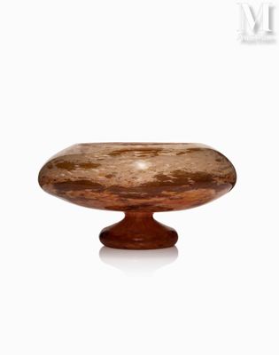 un saladier en verre posé sur un socle en bois, lui-même posé sur une surface blanche