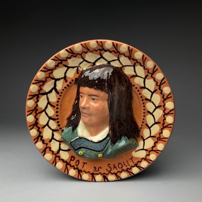 une assiette en céramique sur laquelle est représentée une femme
