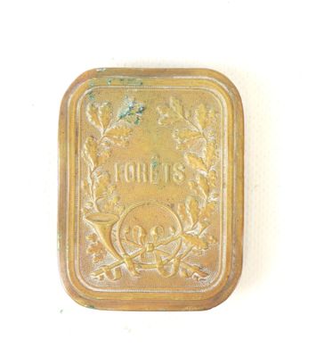a small metal box with a gold label on it