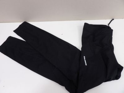 Le pantalon noir est posé sur une surface blanche.