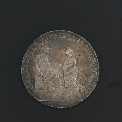 une vieille pièce d'argent sur laquelle figurent un homme et une femme