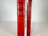two red books sitting next to each other on a table