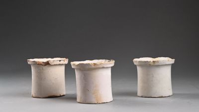 trois vases blancs posés les uns à côté des autres sur une table