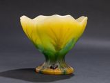 a yellow and green flower shaped vase sitting on a table
