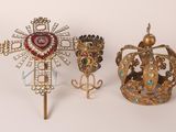 deux couronnes et une croix sont posées sur une surface blanche