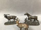 deux statues d'animaux en bronze et une chèvre sur un fond blanc