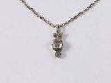 a close up of a necklace with a small owl on it