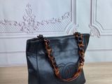 black leather handbag with tortoise chain handles