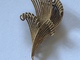 une broche dorée sur laquelle est représenté un oiseau