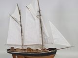 a model of a sailboat on a wooden stand