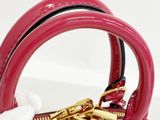 a red purse with a gold handle on a white surface