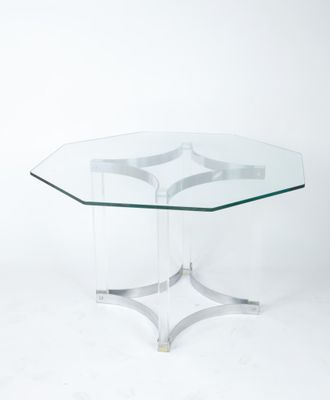 une table basse en verre avec un piètement en métal et un plateau en verre transparent