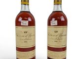 deux bouteilles de vin posées l'une à côté de l'autre sur une surface blanche