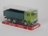 un petit camion jouet vert et vert dans une boîte transparente