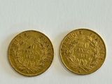 two gold coins sitting side by side on a white surface