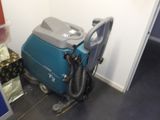 une machine bleue et grise posée par terre