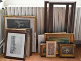 many framed pictures on the floor next to a radiator