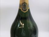 une bouteille de champagne posée sur une table blanche, sur fond blanc