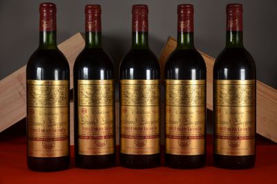 four bottles of wine are lined up on a red table