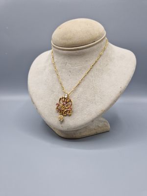 un collier en or avec un pendentif en forme de fleur sur un mannequin