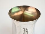 a silver cup that has a monogram on it