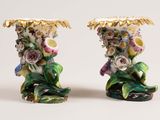 two vases with flowers on them on a white surface