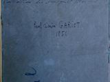 an old book sitting on top of a wooden table with writing on it