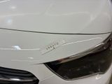 a close up of a white car with a sticker on it