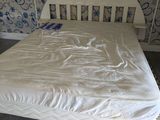 a white bed in a room with a blue and white wallpaper