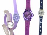 Quatre montres de couleurs différentes sont alignées sur une surface blanche