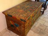 a wooden chest sitting on a tiled floor next to a chair