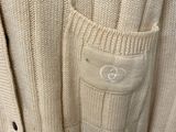 the back of a white sweater with a buttoned pocket on it