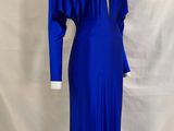 a blue dress on a mannequin stand against a white backdrop