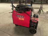 a small red machine with a hose on top of it