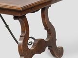 a wooden table with a wrought iron base and a wooden top
