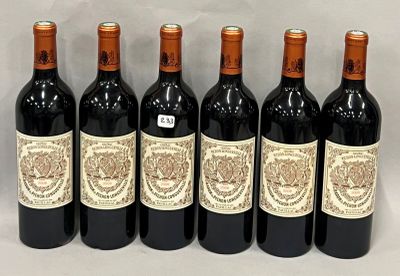 six bottles of wine are lined up in a row on a table
