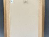 an empty picture frame with a rope hanging from it ' s side