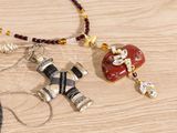 two necklaces that have been placed on a wooden table